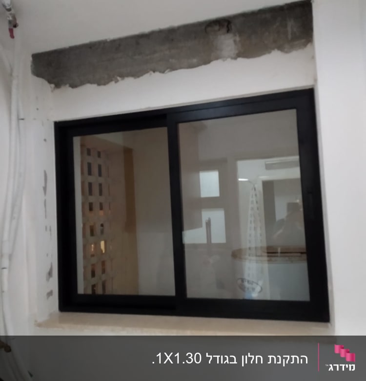 חלון אלומיניום עם מסגרת שחורה בקיר לבן